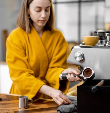 Met weinig moeite meer luxe in je huis vrouw thuis koffie aan het maken met een koffiemachine